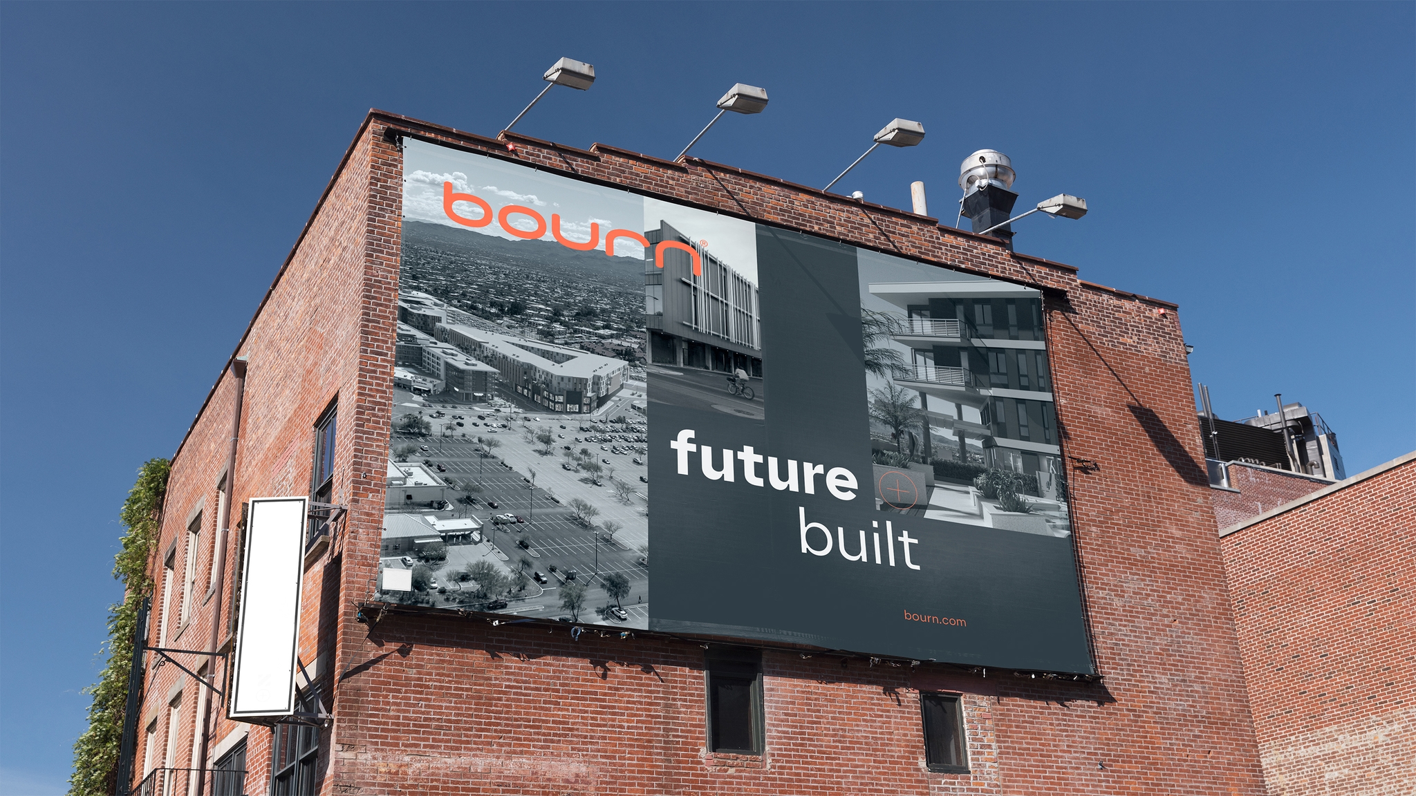 A very large sign on the side of a red brick building showing a marketing image as part of the bourn rebrand with the message future built.